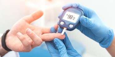 Doktor kan şekeri seviyesini glukometre ile kontrol ediyor